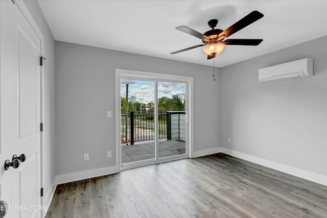 unfurnished room featuring ceiling fan, light wood-type flooring, and a wall unit AC