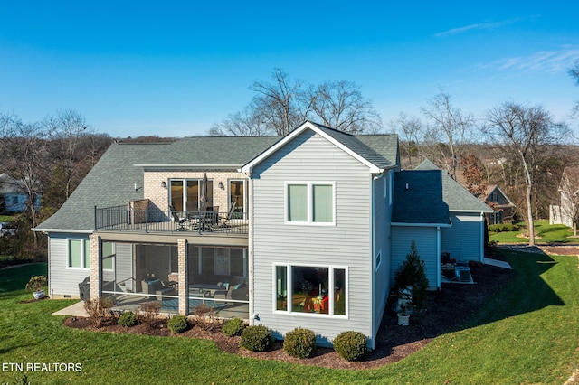 rear view of house featuring a lawn, a patio area, a balcony, and a pool