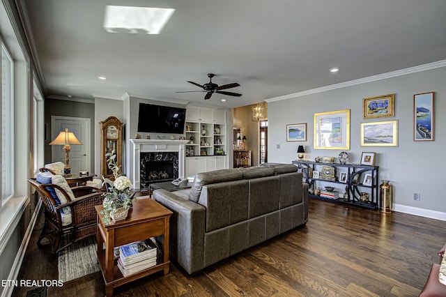 living room with a premium fireplace, built in features, ceiling fan, and crown molding