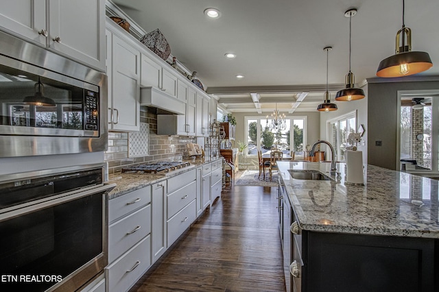 kitchen with beamed ceiling, a large island, sink, and stainless steel appliances