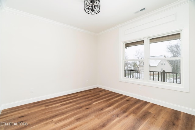 empty room with hardwood / wood-style flooring and ornamental molding