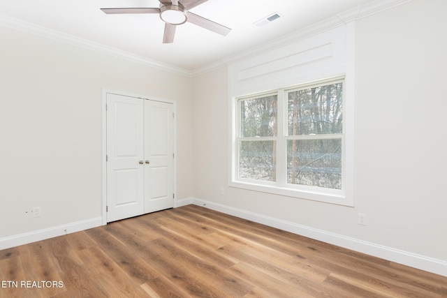 unfurnished room featuring ceiling fan, wood-type flooring, and crown molding