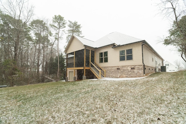 rear view of house featuring a sunroom and a yard