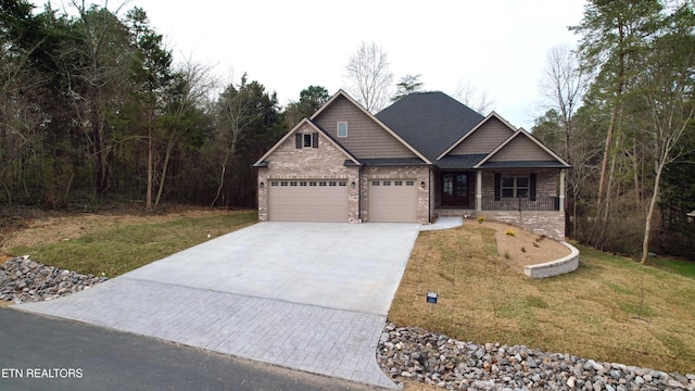 craftsman-style home featuring a front yard, brick siding, driveway, and an attached garage