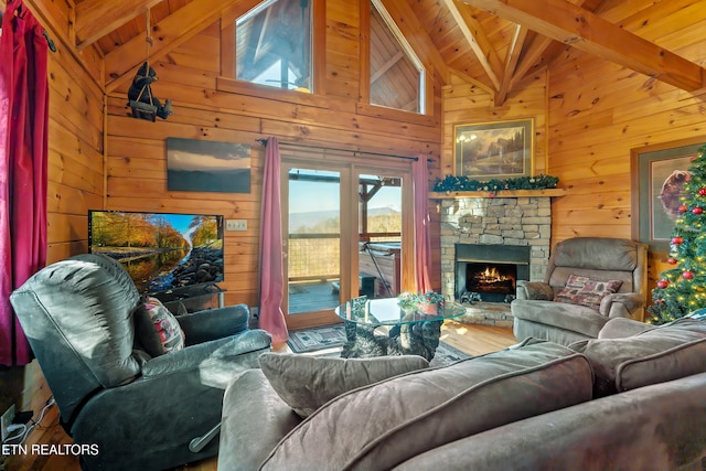 living room with wood walls, beam ceiling, a fireplace, wooden ceiling, and wood-type flooring