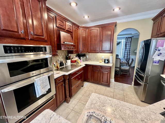 kitchen featuring tasteful backsplash, crown molding, light tile patterned floors, and stainless steel appliances