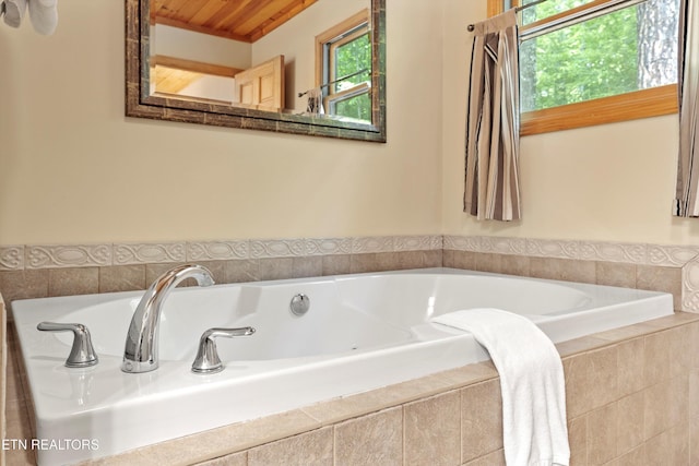 bathroom featuring tiled tub and wood ceiling