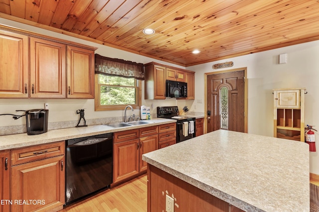 kitchen with sink, a center island, light hardwood / wood-style flooring, crown molding, and black appliances