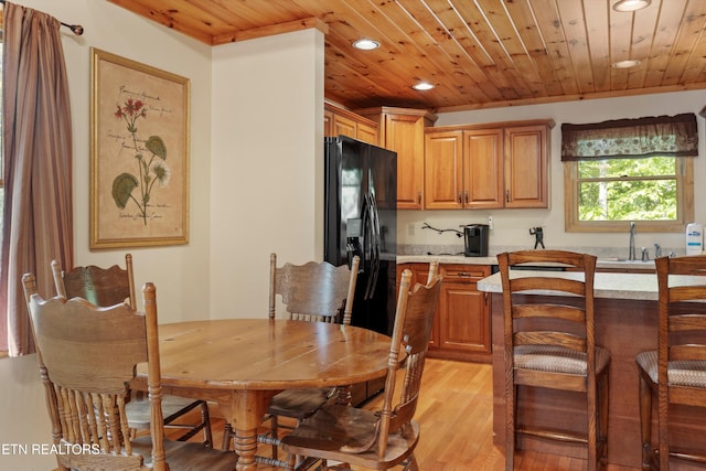 dining area featuring light hardwood / wood-style flooring, wood ceiling, and sink