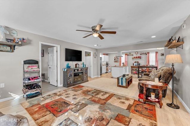 living room with ceiling fan and light hardwood / wood-style floors