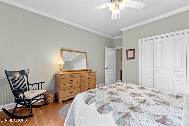 bedroom featuring a closet, ornamental molding, light hardwood / wood-style flooring, and ceiling fan