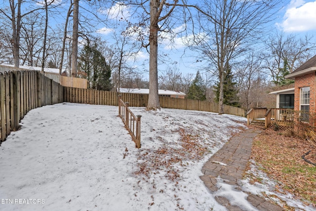 snowy yard featuring a deck