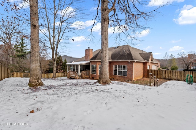 snow covered rear of property featuring a wooden deck