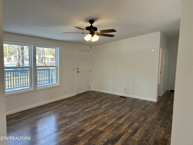 unfurnished room with ceiling fan, dark hardwood / wood-style floors, and a textured ceiling