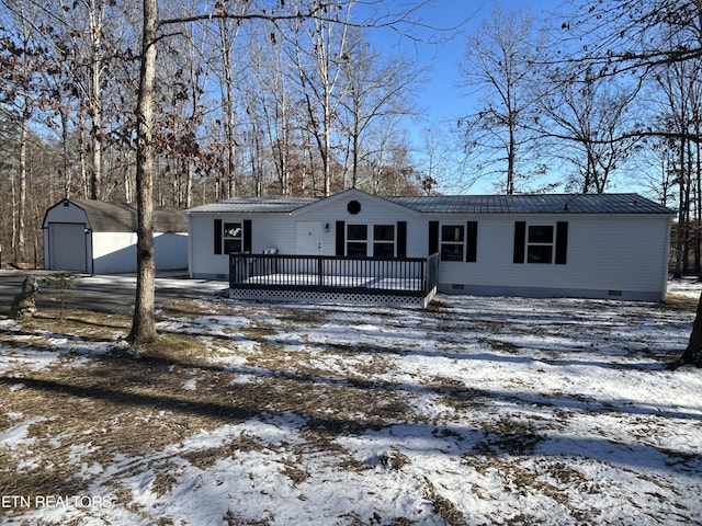 view of front of home with a deck, an outdoor structure, and a garage