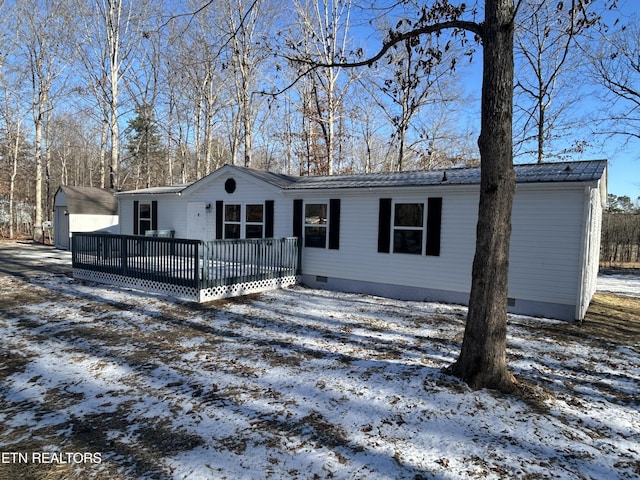 view of front of house with a wooden deck and a storage unit