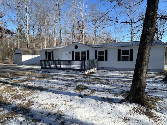 view of front of property featuring a garage, a deck, and a storage unit