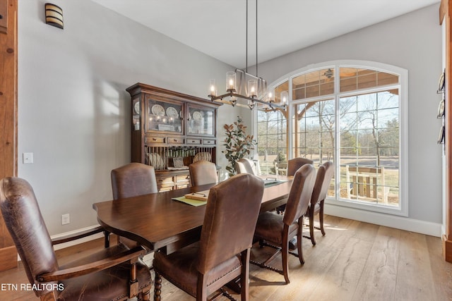 dining area with a chandelier and light hardwood / wood-style flooring