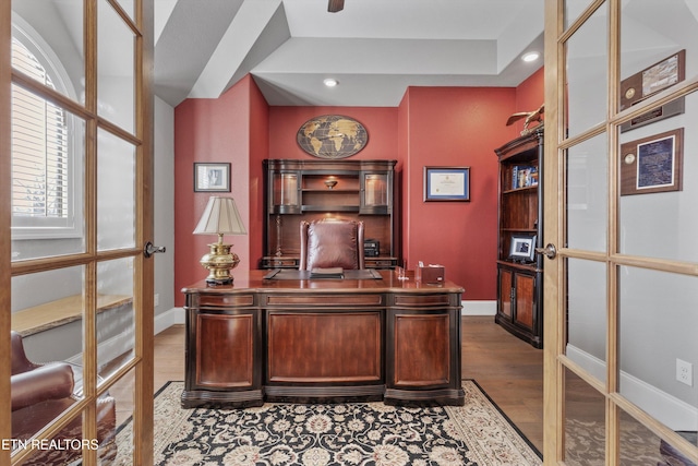 office with light hardwood / wood-style flooring and french doors