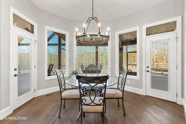 dining area with dark wood-type flooring and a chandelier