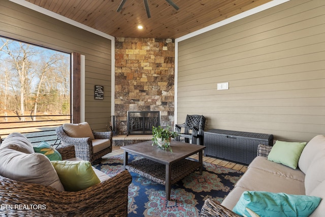 living room featuring radiator heating unit, an outdoor stone fireplace, wooden walls, ceiling fan, and wooden ceiling