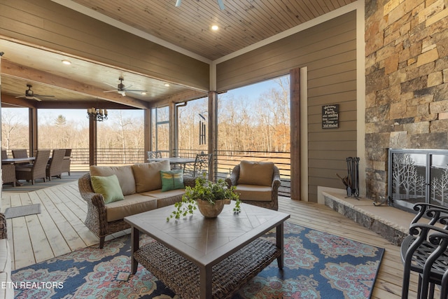 sunroom / solarium featuring ceiling fan, wood ceiling, and plenty of natural light