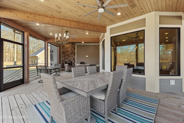 sunroom with wooden ceiling, an outdoor brick fireplace, ceiling fan with notable chandelier, and beamed ceiling