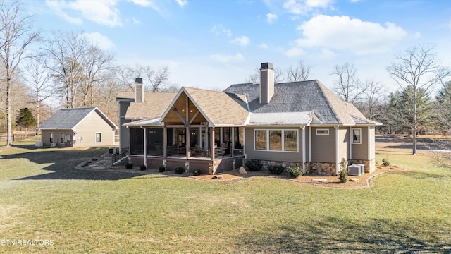 back of property featuring a sunroom, a lawn, and central air condition unit