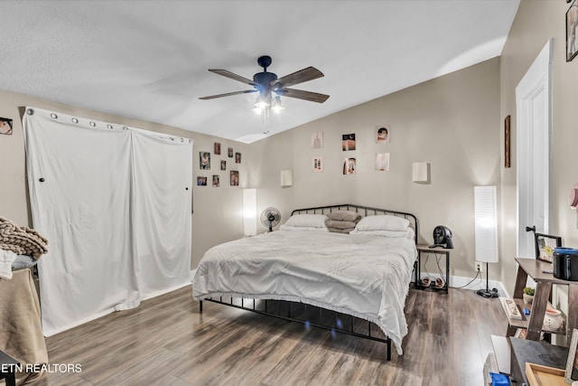 bedroom featuring ceiling fan, lofted ceiling, and dark hardwood / wood-style floors