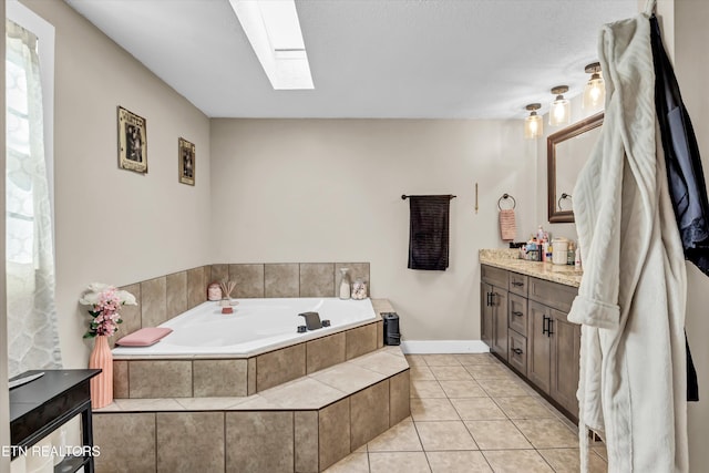 bathroom featuring vanity, a relaxing tiled tub, a skylight, and tile patterned floors