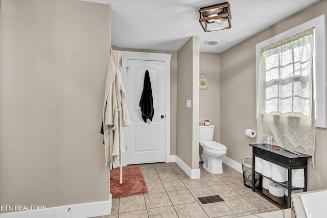 bathroom with toilet and tile patterned flooring