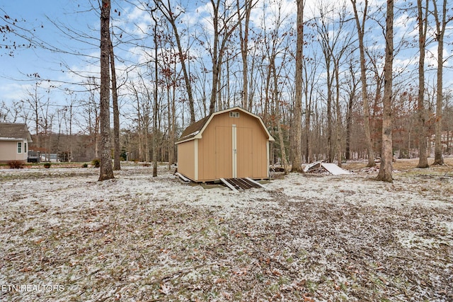 yard layered in snow with a storage shed