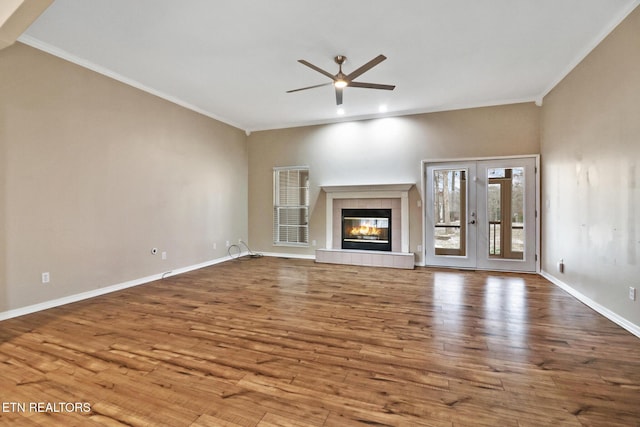 unfurnished living room with a fireplace, wood-type flooring, ceiling fan, and crown molding