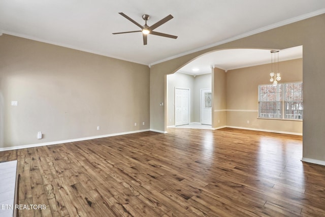 empty room featuring hardwood / wood-style flooring, ceiling fan with notable chandelier, and ornamental molding