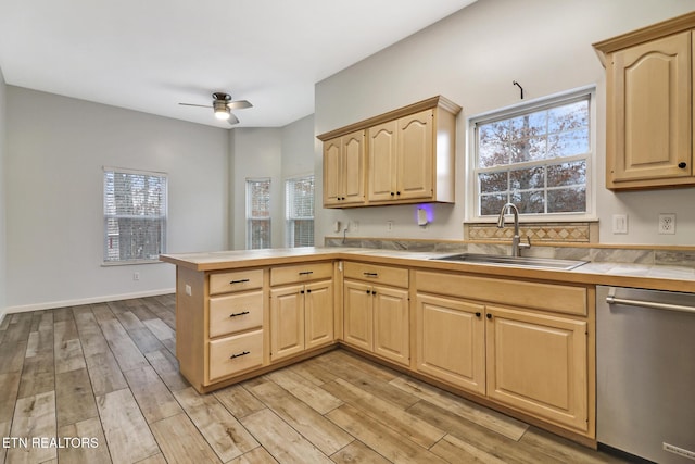 kitchen featuring light brown cabinetry, light hardwood / wood-style floors, stainless steel dishwasher, and sink