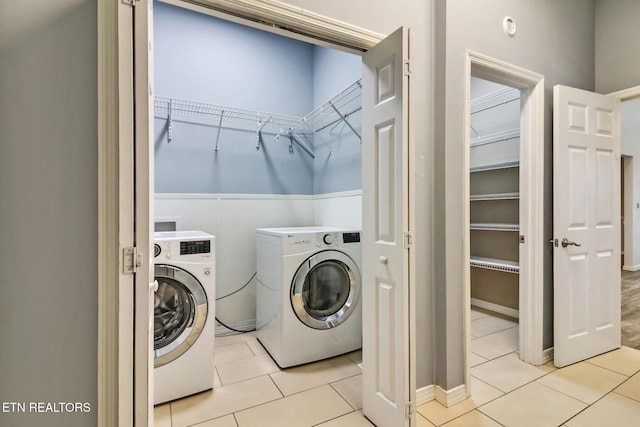 laundry room featuring washer and clothes dryer and light tile patterned flooring