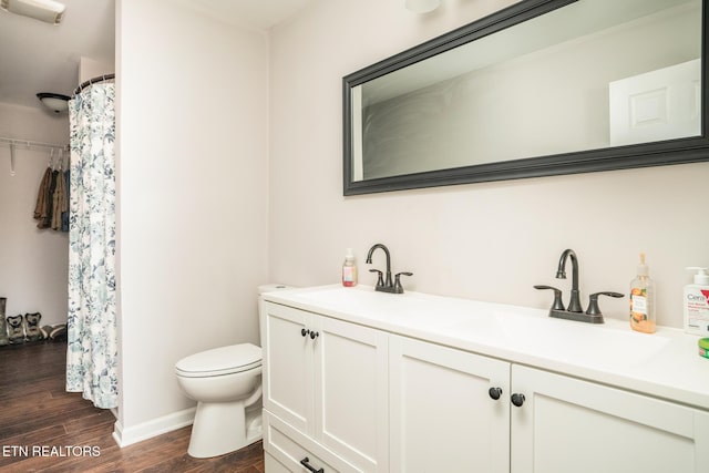 bathroom featuring toilet, vanity, and wood-type flooring