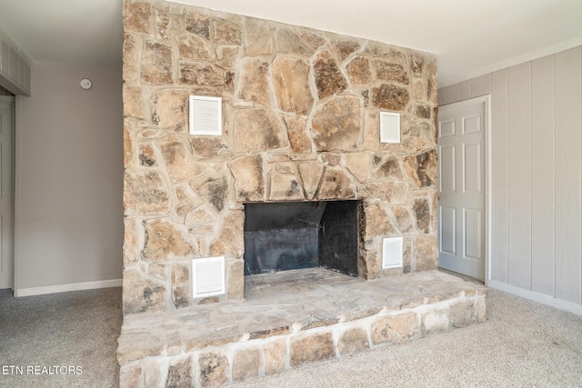 interior details featuring carpet floors, a fireplace, and wood walls