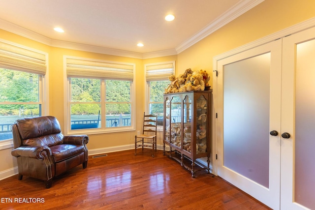 sitting room with visible vents, baseboards, wood finished floors, crown molding, and french doors