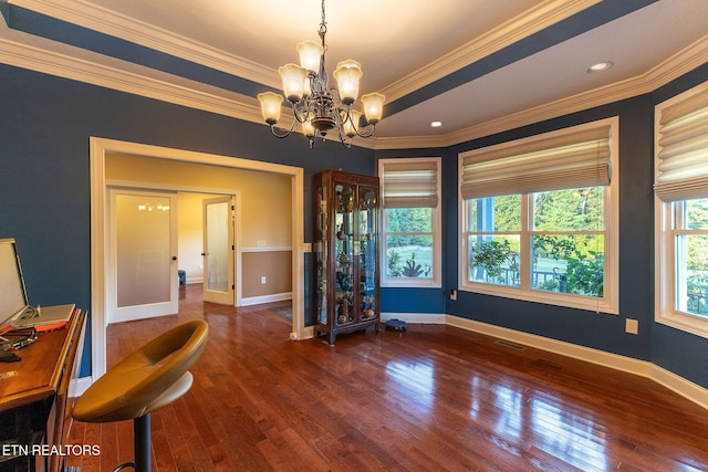 unfurnished dining area featuring dark hardwood / wood-style flooring, ornamental molding, and a notable chandelier