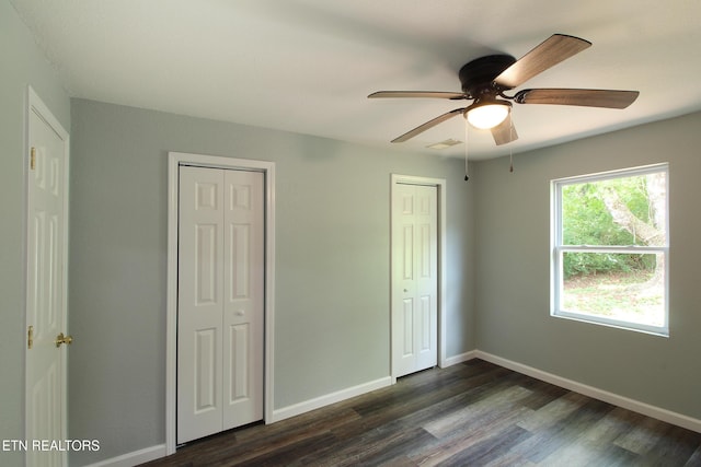 228 Pedigo Rd, Madisonville, TN 37354 - unfurnished bedroom with multiple closets, dark wood-type flooring, and a ceiling fan