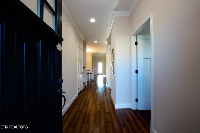 hallway with dark wood-type flooring and ornamental molding