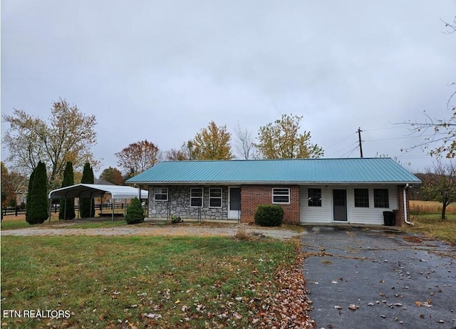 single story home featuring a front lawn and a carport