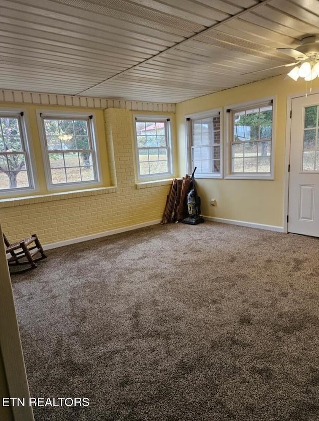 unfurnished sunroom featuring ceiling fan