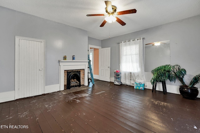 unfurnished living room with a textured ceiling, ceiling fan, and dark hardwood / wood-style floors