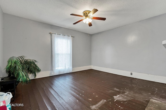 empty room featuring ceiling fan, dark hardwood / wood-style floors, and a textured ceiling