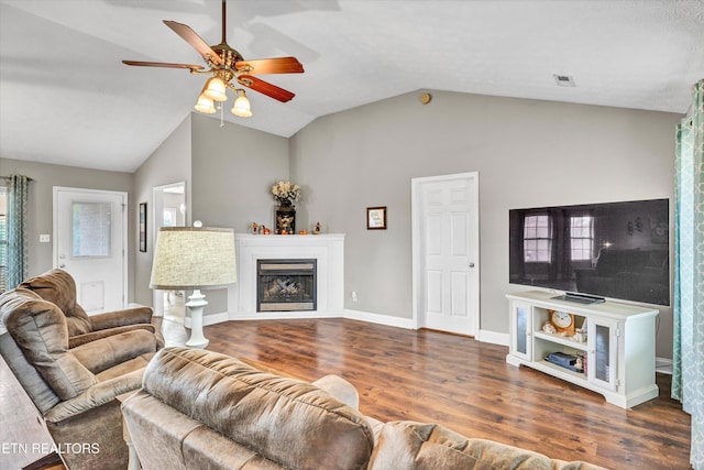 living room with lofted ceiling, ceiling fan, and dark wood-type flooring