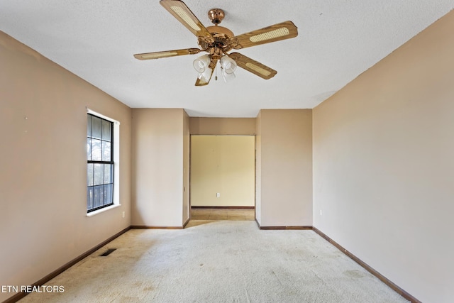 carpeted empty room with ceiling fan and a textured ceiling