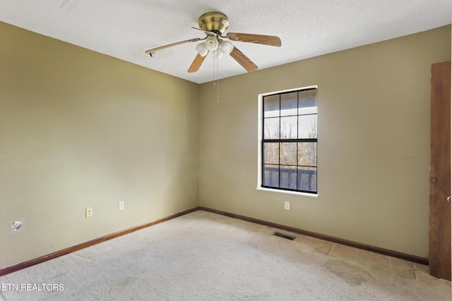 empty room with ceiling fan, a textured ceiling, and light carpet