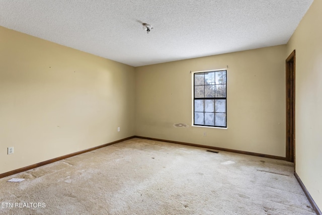 carpeted spare room featuring a textured ceiling